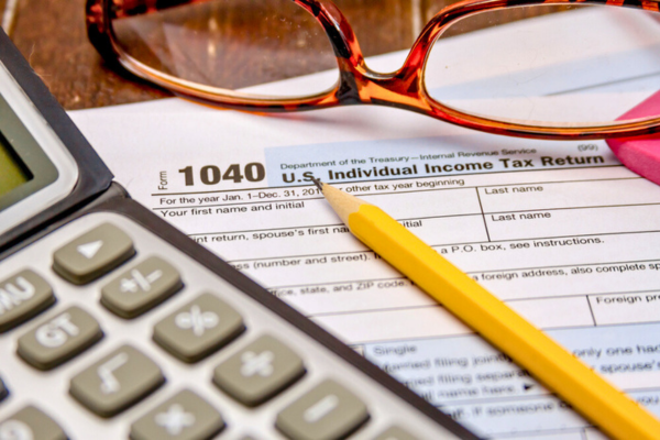 Close up do formulário de imposto com lápis, borracha rosa e calculadora.