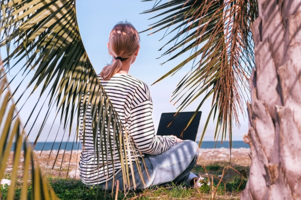 Trabalho remoto com freelancer trabalhando remotamente na praia.